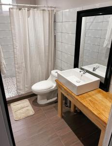 La salle de bains est pourvue d'un lavabo blanc et de toilettes. dans l'établissement Habitacion privada Lamat I, à San Pedro de la Laguna