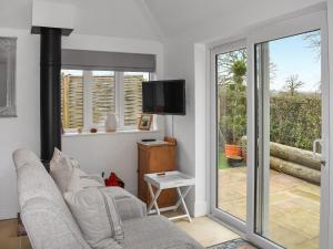 a living room with a couch and a sliding glass door at Cripps Cottage Annex in Hassocks