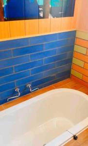 y baño con bañera y azulejos azules. en guesthouseOHANA!セルフチェックイン!団体様ファミリー様向き!海浜公園近く, en Hitachinaka