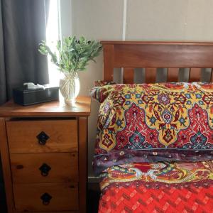 a bedroom with a bed with a pillow and a night stand at Corella Creek Country Farm Stay in Nelia