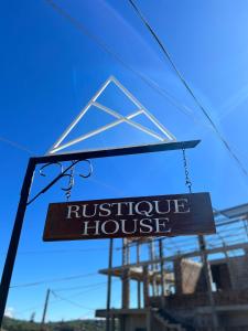 a sign for a rustic house hanging from a window at Rustique House dbl in Nuwara Eliya