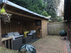 a patio with wicker couches in a backyard at The Barn in Trotterscliffe