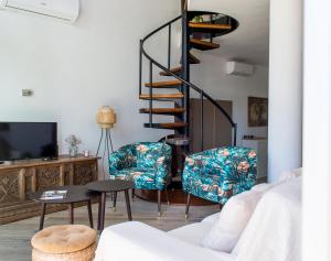 a living room with a spiral staircase and two chairs at La Botigueta de Bellmunt in Penellas