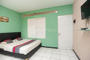 um quarto com uma cama e uma janela em J&B Rooms Pramuka Jakarta Mitra RedDoorz em Jakarta