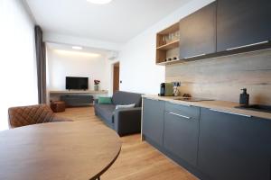 a kitchen with a table and a living room at Apartment Dolfi, Senec in Senec