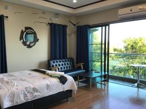 a bedroom with a bed and a chair and a window at Turtle Nest in Khao Tao