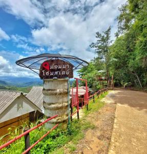 un panneau pour un refuge de montagne sur le côté d'une route dans l'établissement ม่อนนาป่าบงเปียง โฮมสเตย์, à Ban Mae Pan Noi