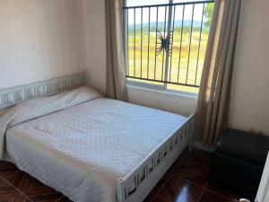 een kleine slaapkamer met een bed en een raam bij Casa los cabreras in Quillón