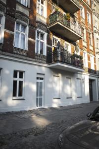 a white building with two balconies on a street at Apartament Conces II in Wrocław