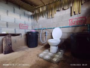 a bathroom with a toilet and a trash can at ม่อนนาป่าบงเปียง โฮมสเตย์ in Ban Mae Pan Noi