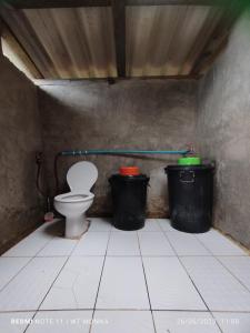 a bathroom with a toilet and two trash cans at ม่อนนาป่าบงเปียง โฮมสเตย์ in Ban Mae Pan Noi