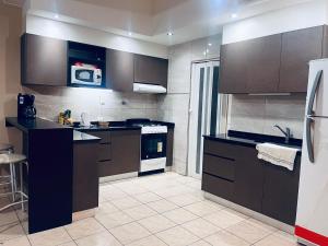 a kitchen with brown cabinets and a white appliance at Duplex Centrico in Termas de Río Hondo