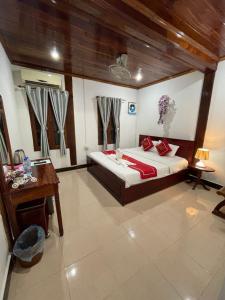a bedroom with a bed and a table and a desk at Ouis NamKhan Place House in Luang Prabang