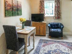 a living room with a table and two chairs and a television at Honeysuckle Cottage - Uk4177 in Mayfield