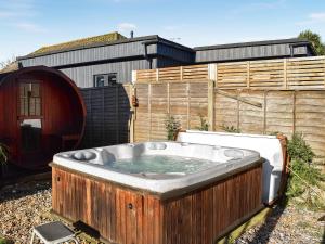 a hot tub in a yard next to a fence at Wessex Studio in East Wittering