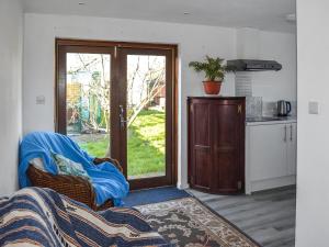 a living room with a kitchen and a door to a yard at Wessex Studio in East Wittering