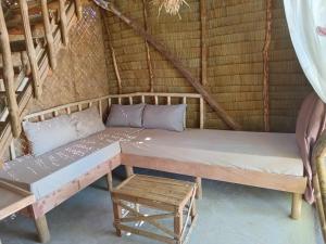 a bed and a table in a room at BICE Camp Bucana Beach in El Nido