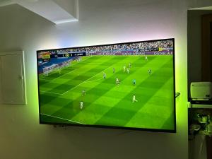 una TV a schermo piatto appesa a un muro con una partita di calcio di Blanca a Kaštela (Castelli)