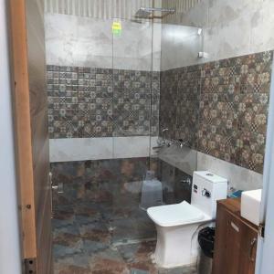 a bathroom with a toilet and a shower at Hotel Pearl Residency in Mukteswar