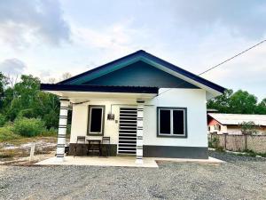 una pequeña casa con techo azul en HH Homestay Dungun, en Kampong Gok Kapor