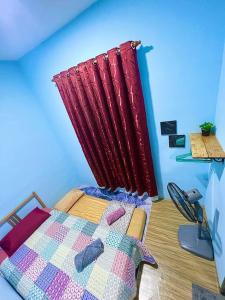 1 dormitorio con 1 cama con cortina roja en HH Homestay Dungun en Kampong Gok Kapor