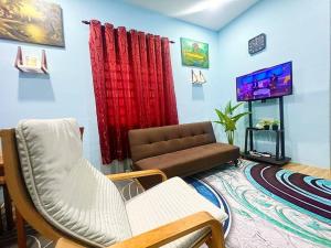a living room with a couch and a tv at HH Homestay Dungun in Kampong Gok Kapor