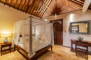 a bedroom with a bed with a mosquito net at Honeymoon Guesthouse in Ubud