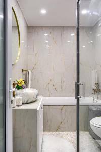 a bathroom with a shower and a sink and a toilet at Sika Luxury Apartment in Arad