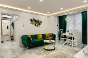 a living room with a green couch and a table at Sika Luxury Apartment - cazare premium Arad - self check-in in Arad