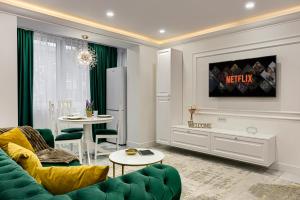 a living room with a green couch and a table at Sika Luxury Apartment in Arad