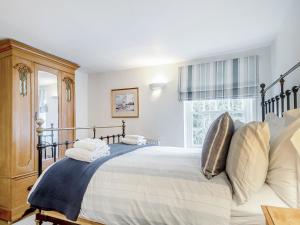 a bedroom with a large bed and a window at September Cottage in Wenhaston