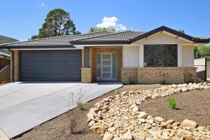 a house with a garage and a driveway at Alpine Knights Stylish Luxury in Bright
