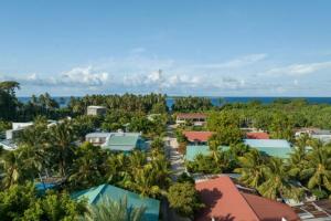 バア環礁にあるHanifaru Beach Innのヤシの木と海の空中を望むリゾートです。