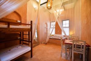 a room with two bunk beds and a table and chairs at Tulia Old Town in Mombasa