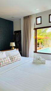 a bedroom with a bed with a view of a pool at Canal Village Pakpra Phatthalung in Phatthalung
