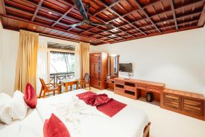 1 dormitorio con cama blanca y almohadas rojas en Cherai Beach View Heritage en Cherai Beach