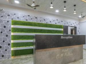 un vestíbulo con una pared con rayas verdes y blancas en HOTEL CM PALACE & GUEST HOUSE & P.G ROOMS, en Kalol