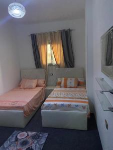 a bedroom with two beds and a tv and a window at desert horus hotel in Cairo