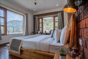 - une chambre avec un lit et une grande fenêtre dans l'établissement SaffronStays Wood Sparrow, à Bhimtal