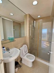 a bathroom with a toilet and a sink and a shower at Simple and elegant 2BR with washer in Manila