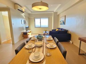 mesa de comedor con sillas y sala de estar. en Simple and elegant 2BR with washer en Manila