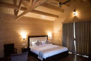 een slaapkamer met een groot bed in een houten kamer bij Sun Hotel and Resort, Mount Abu in Abu Road