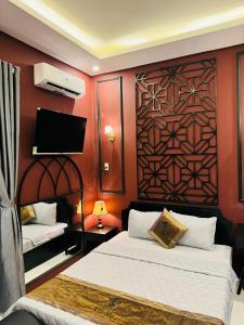ein Hotelzimmer mit 2 Betten und einem TV in der Unterkunft NHÀ NGHỈ TÚ SỰ in Vĩnh Long