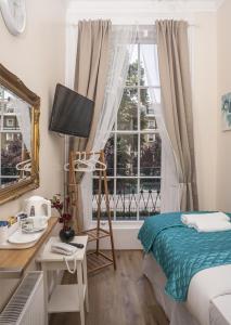 een slaapkamer met een bed, een bureau en een raam bij ABC Hyde Park Hotel in Londen