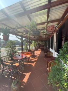 a patio with tables and chairs under a pergola at Ouis NamKhan Place House in Luang Prabang