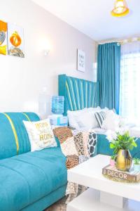 uma sala de estar com um sofá azul e uma mesa em Luxe Oasis em Nairobi