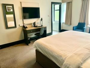 a hotel room with a bed and a desk and a television at Park Inn by Radisson Bournemouth in Bournemouth