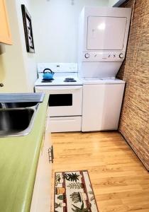 a kitchen with white appliances and a wooden floor at EVCharger, Free Parking, Ski, Golf, BBQ, Awesomeness in Invermere