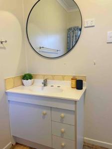 bagno con lavandino e specchio di Rose Bay beach views cosy apartment a Bowen