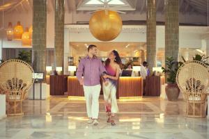 un hombre y una mujer de pie en un vestíbulo en Bahia Principe Luxury Esmeralda All Inclusive - Newly Renovated en Punta Cana